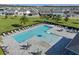 L-shaped community pool with plenty of lounge chairs and tables at 771 Annabell Ridge Rd, Minneola, FL 34715