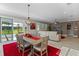 Bright dining room features a rustic table, red rug, and access to the backyard at 771 Annabell Ridge Rd, Minneola, FL 34715