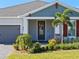 House entrance with gray door, stone accents, and palm trees at 771 Annabell Ridge Rd, Minneola, FL 34715