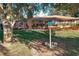 Ranch style home with a large backyard, deck, and mature tree at 9835 Lakeshore Dr, Clermont, FL 34711