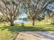 Landscaped backyard with a brick patio and lake view at 9835 Lakeshore Dr, Clermont, FL 34711