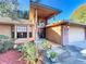 Attractive house exterior with a two-car garage and well-maintained landscaping at 9835 Lakeshore Dr, Clermont, FL 34711