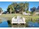 Lake access with a wooden dock and lily pads at 9835 Lakeshore Dr, Clermont, FL 34711