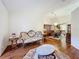 Spacious living room with hardwood floors, a view into the dining area, and comfortable seating at 9835 Lakeshore Dr, Clermont, FL 34711