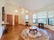 Sunlit living room with hardwood floors, a bay window, and access to the foyer at 9835 Lakeshore Dr, Clermont, FL 34711