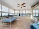 Bright sunroom with tile floors, window seating, and a ceiling fan at 9835 Lakeshore Dr, Clermont, FL 34711