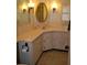 Corner vanity with an oval mirror and tiled flooring at 101 Mango Cv, Leesburg, FL 34748