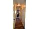 Long hallway with wood-look flooring and access to bedrooms at 101 Mango Cv, Leesburg, FL 34748