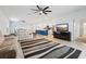 Bright living room features a comfy sofa, large TV, and open concept kitchen at 1115 Calico Pointe Cir, Groveland, FL 34736