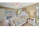 Comfortable bedroom with ceiling fan, white bed, and access to pool view at 1281 Gray Ct, Eustis, FL 32726
