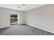 Bedroom with grey carpet, ceiling fan and sliding glass doors to deck at 13340 Country Club Dr, Tavares, FL 32778