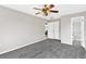 Spacious bedroom with ceiling fan, carpet, and access to bathroom at 13340 Country Club Dr, Tavares, FL 32778
