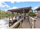 Covered boat slip with a wooden dock and calm water views at 13340 Country Club Dr, Tavares, FL 32778