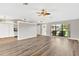 Open living area with wood-look floors and multiple windows at 13340 Country Club Dr, Tavares, FL 32778