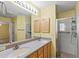 Double vanity bathroom with wood cabinets and a shower at 17848 Se 87Th Bourne Ave, The Villages, FL 32162