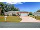 Charming one-story home, featuring a two-car garage and manicured lawn at 202 Forest Park Ln, Lady Lake, FL 32159
