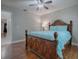 Bedroom with wooden bed frame, light blue bedding, and ceiling fan at 2247 Cypress Cove Dr # E2, Tavares, FL 32778