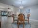 Dining room with glass table, four chairs, and view into living room at 2247 Cypress Cove Dr # E2, Tavares, FL 32778