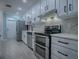 Modern kitchen with white cabinets, stainless steel appliances, and marble countertops at 2247 Cypress Cove Dr # E2, Tavares, FL 32778