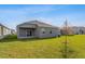 Back exterior view showing a house with a covered patio at 2878 Supermarine Rd, Tavares, FL 32778