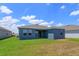 Rear view of a blue house with a grassy backyard at 2992 Supermarine Rd, Tavares, FL 32778