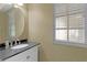 Small bathroom with granite countertop, white vanity, and oval mirror at 3614 Kingswood Ct, Clermont, FL 34711
