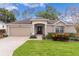 Single-story house with a two-car garage and well-manicured lawn at 3614 Kingswood Ct, Clermont, FL 34711