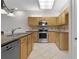 Bright kitchen features stainless steel appliances and ample wood cabinetry at 3614 Kingswood Ct, Clermont, FL 34711