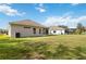 Spacious backyard with a large grassy area and screened enclosure at 3640 Mount Hope Loop, Leesburg, FL 34748