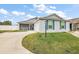 House exterior showcasing a light beige vinyl siding and a two-car garage at 4056 Venetian Ln, The Villages, FL 32163