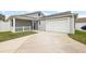 View of the garage and backyard, showing a concrete driveway and grassy area at 4056 Venetian Ln, The Villages, FL 32163