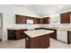 L-shaped kitchen with island, microwave, dishwasher, and wood cabinets at 4056 Venetian Ln, The Villages, FL 32163