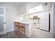 White kitchen with breakfast bar and light wood floors at 4566 County Road 116, Wildwood, FL 34785