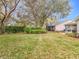 Large backyard with mature trees and a view of the screened patio at 4817 Summerbridge Cir, Leesburg, FL 34748