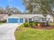 House exterior with blue garage doors and well-maintained landscaping at 4817 Summerbridge Cir, Leesburg, FL 34748