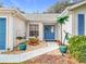 Front entry with blue door, landscaping, and walkway at 4817 Summerbridge Cir, Leesburg, FL 34748