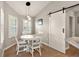 Bright breakfast nook with a white table and gray chairs, near a barn door at 5312 Galley Way, Oxford, FL 34484