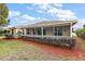 House exterior showcasing landscaping and screened porch at 5312 Galley Way, Oxford, FL 34484