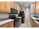 Clean kitchen with light wood cabinets and black appliances at 5312 Galley Way, Oxford, FL 34484