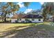 Back of house, featuring a large yard and mature trees at 5409 Twin Palms Rd, Fruitland Park, FL 34731