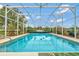 Inviting screened-in pool with surrounding patio furniture at 8709 Augusta Ct, Clermont, FL 34711