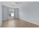 Spacious bedroom with wood-look floors and a window with curtains at 9224 Se 167Th Ford St, The Villages, FL 32162