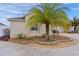 Landscaped yard with palm tree and stone border next to tan house at 9224 Se 167Th Ford St, The Villages, FL 32162