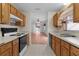 Kitchen with wood cabinets, white appliances, and tile floor at 952 Avalon Ave, The Villages, FL 32159