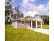 Gray house with white accents, covered porch, and a grassy yard at Lot 17 Indian Estates Cr 423, Lake Panasoffkee, FL 33538