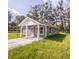 Gray house with white accents, covered porch, and a grassy yard at Lot 17 Indian Estates Cr 423, Lake Panasoffkee, FL 33538
