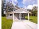 Gray house with white accents, covered porch, and a grassy yard at Lot 17 Indian Estates Cr 423, Lake Panasoffkee, FL 33538