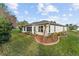 Rear view of house with screened patio and landscaping at 10282 Julia Isles Ave, Oxford, FL 34484