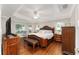 Main bedroom with king bed, wood furniture, and a TV at 10282 Julia Isles Ave, Oxford, FL 34484