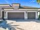 Three-car garage with decorative doors and paver driveway at 1216 Zeek Ridge St, Clermont, FL 34715